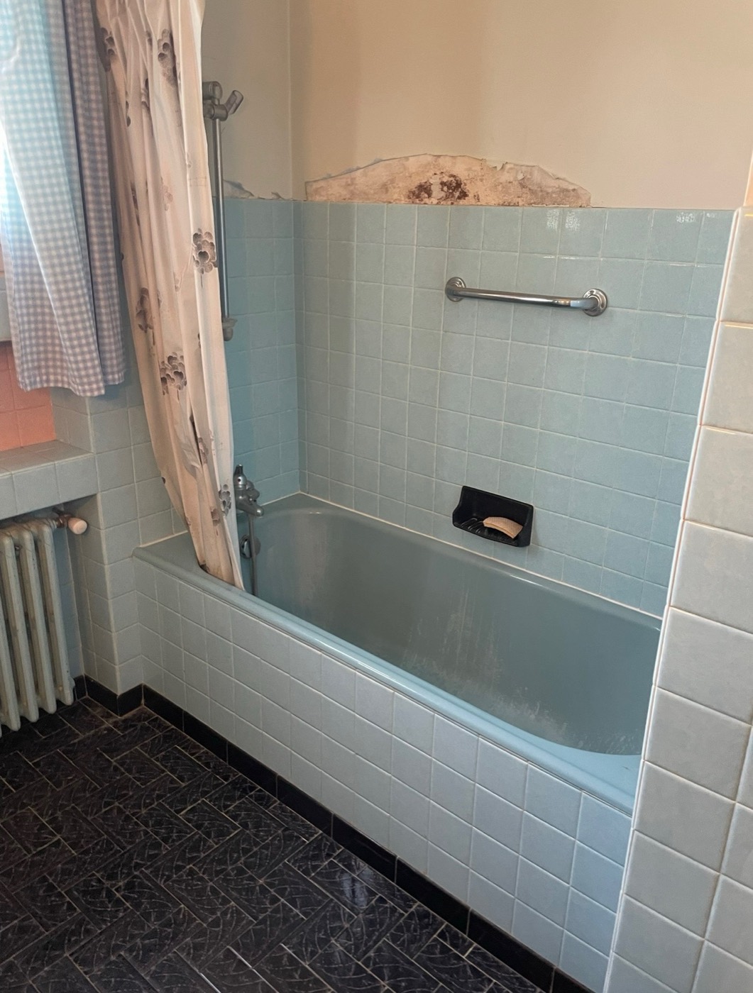Ancienne baignoire encastrée et faïence bleue avant rénovation, salle de bain des années 70