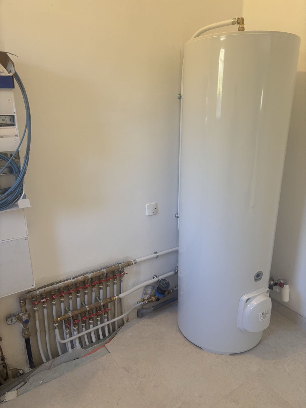 Chauffe-eau au sol raccordé à la nourrice PER d'une maison, avec vannes de coupure repérées