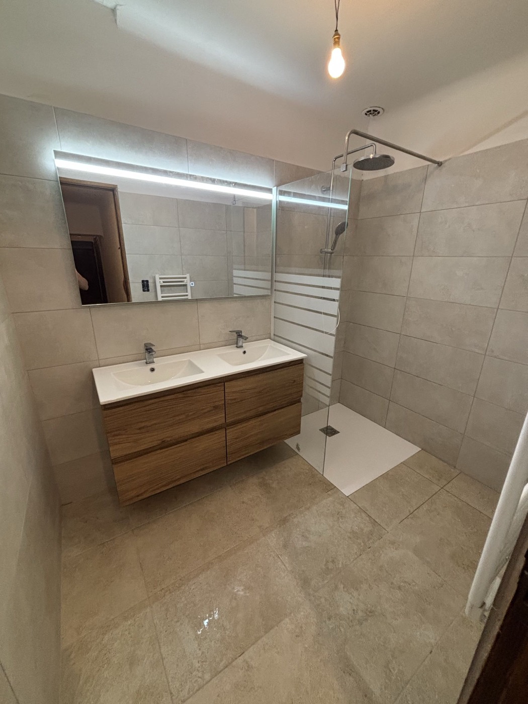 Salle de bain rénovée à Pertuis : douche à l'italienne carrelée, meuble double vasque bois et miroir lumineux