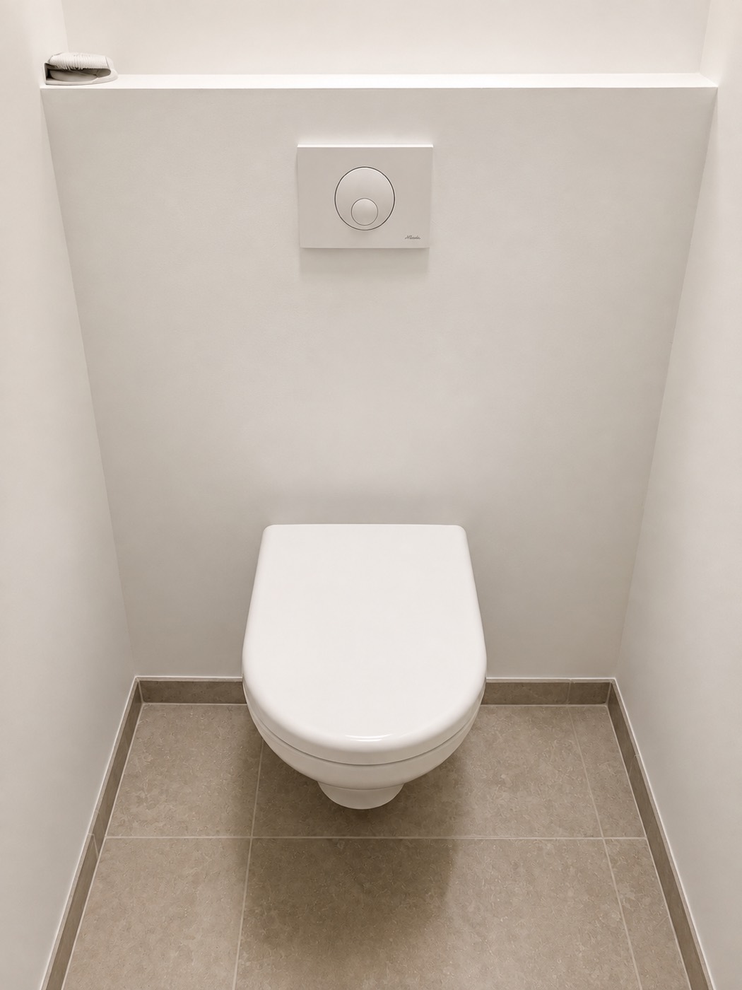 WC suspendu neuf avec plaque de commande encastrée, posé sur bâti-support dans une maison neuve